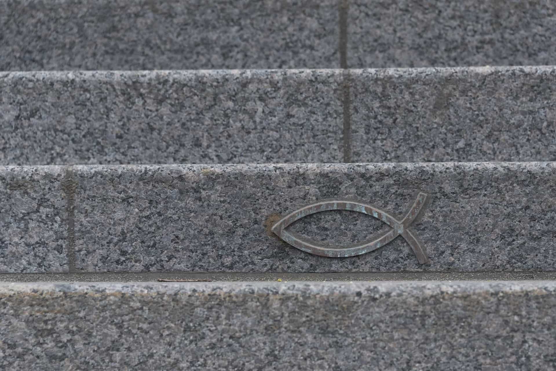 Slide 21 de 31: O uso dos dois arcos interseccionais que se assemelham a um peixe é difundido em todo o mundo. Mas esse símbolo já foi usado como um sinal secreto para os cristãos se identificarem durante os momentos de perseguição. Era comumente encontrado em lugares escondidos de adoração, como catacumbas.