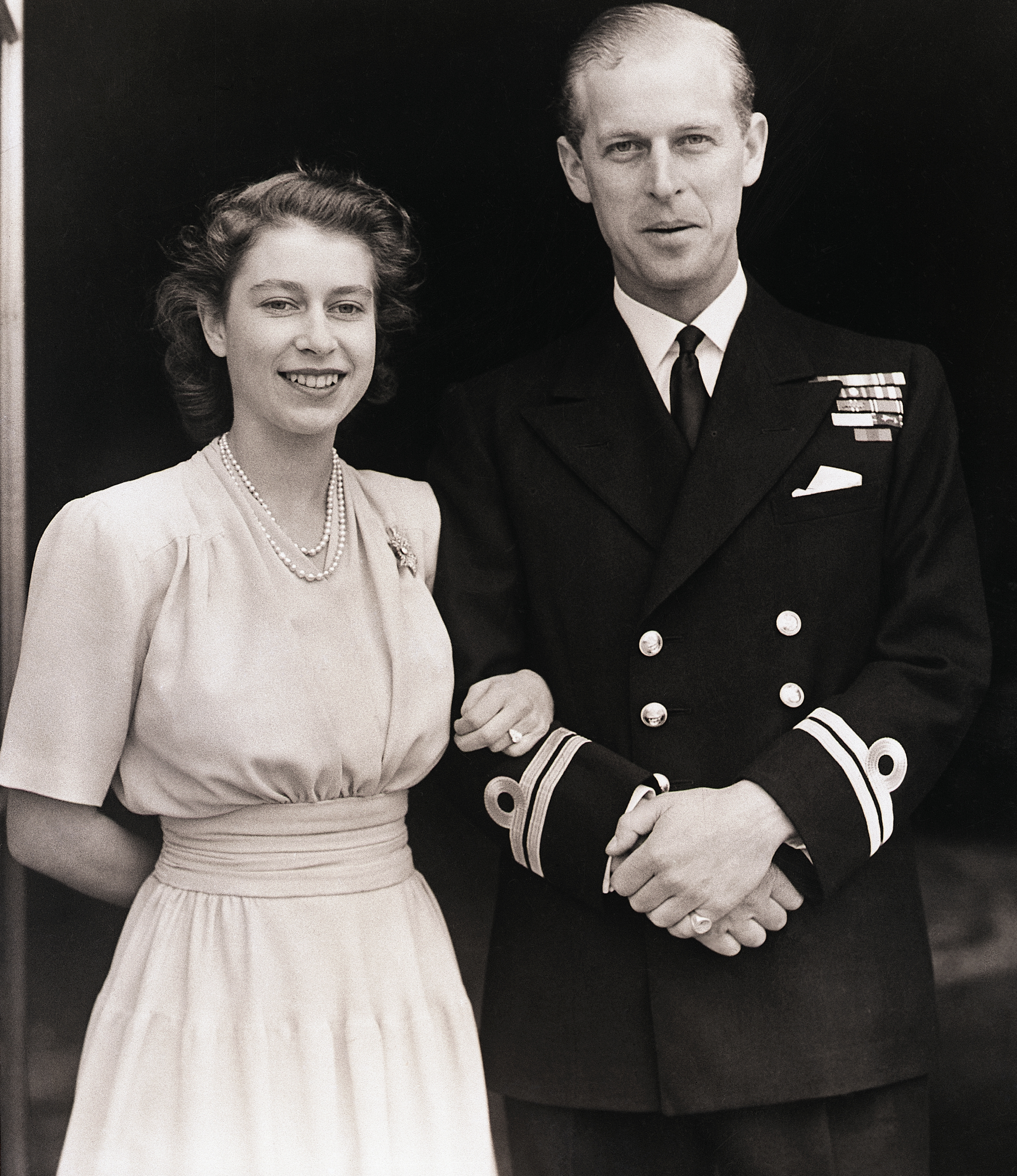 <p>Princess Elizabeth (later Queen Elizabeth II) and Lt. Philip Mountbatten (later Prince Philip, Duke of Edinburgh) posed for an engagement portrait -- showing off her three-stone diamond ring -- at Buckingham Palace upon announcing their betrothal on July 10, 1947.</p>
