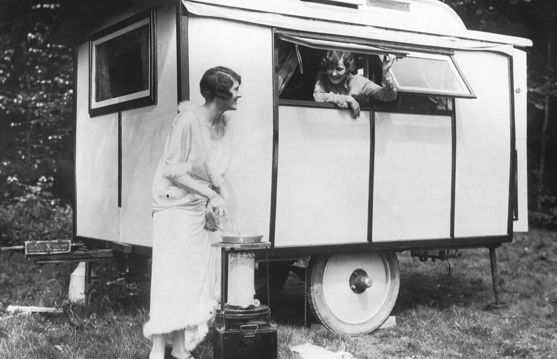 While early RVs and touring cars remained incredibly expensive in the early 1900s (and not everyone could make their own), the trailer grew in popularity. America's car industry boomed in the Roaring Twenties and the trailer represented a portable home-from-home with varying levels of creature comforts. Two women enjoy their trailer vacation in this 1920s shot.