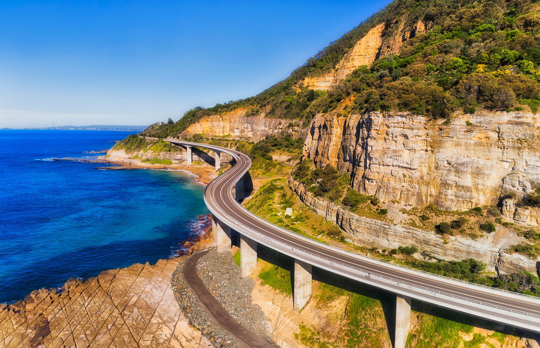 <p>Stretching 87 miles (140km) south from Sydney, the Grand Pacific Drive is a blockbuster of a coastal route. First up is the Royal National Park, the oldest in Australia, with its walking trails to wild beaches. The highway continues south, over the famously photogenic Sea Cliff Bridge, which bends around towering cliffs and past the coastal towns of Wollongong, Shellharbour and Kiama. Stay overnight here and follow the Kiama Coastal Walk to see its famous blowhole, surf beaches and pretty bays – the lesser known Little Blowhole lies further south.</p>  <p><strong><a href="https://www.loveexploring.com/galleries/92044/australias-most-stunning-coastal-towns?page=1">Australia's most stunning coastal towns</a></strong></p>