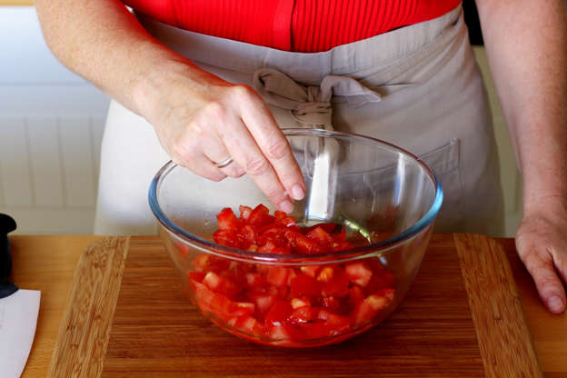 Slide 4 de 14: Coloque os tomates em uma saladeira e adicione o sal.