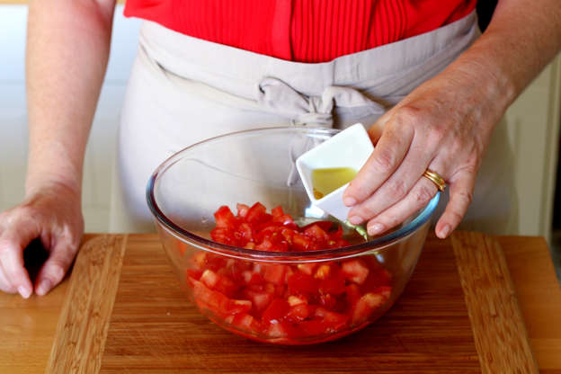 Slide 5 de 14: Coloque o azeite sobre os tomates e misture.