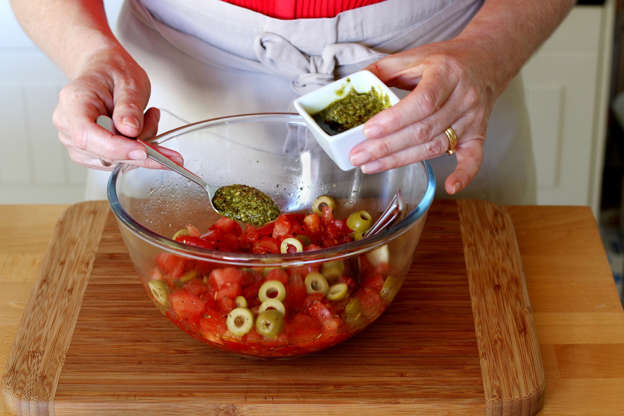Slide 10 de 14: Adicione o pesto aos outros ingredientes da saladeira e misture bem.