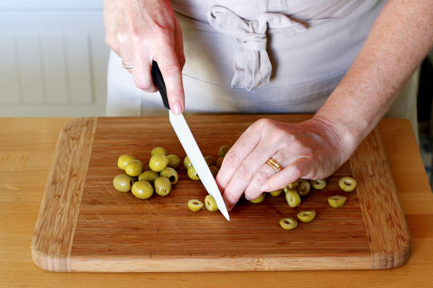 Slide 8 de 14: Retire os caroços das azeitonas (se você não tiver azeitonas sem caroços), corte em fatias e misture aos demais ingredientes na saladeira.