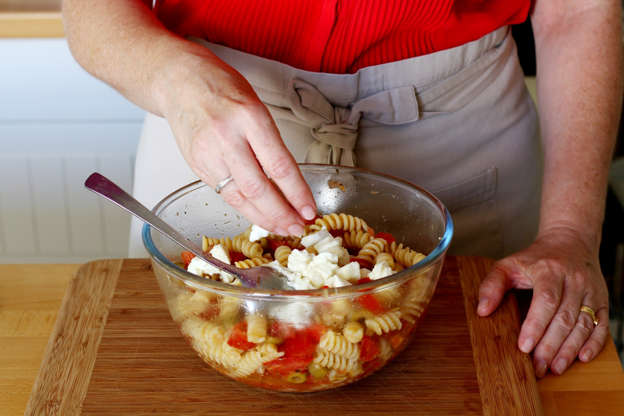 Slide 13 de 14: Adicione a massa ainda quente na saladeira e, em seguinta, coloque a mozzarella e misture.