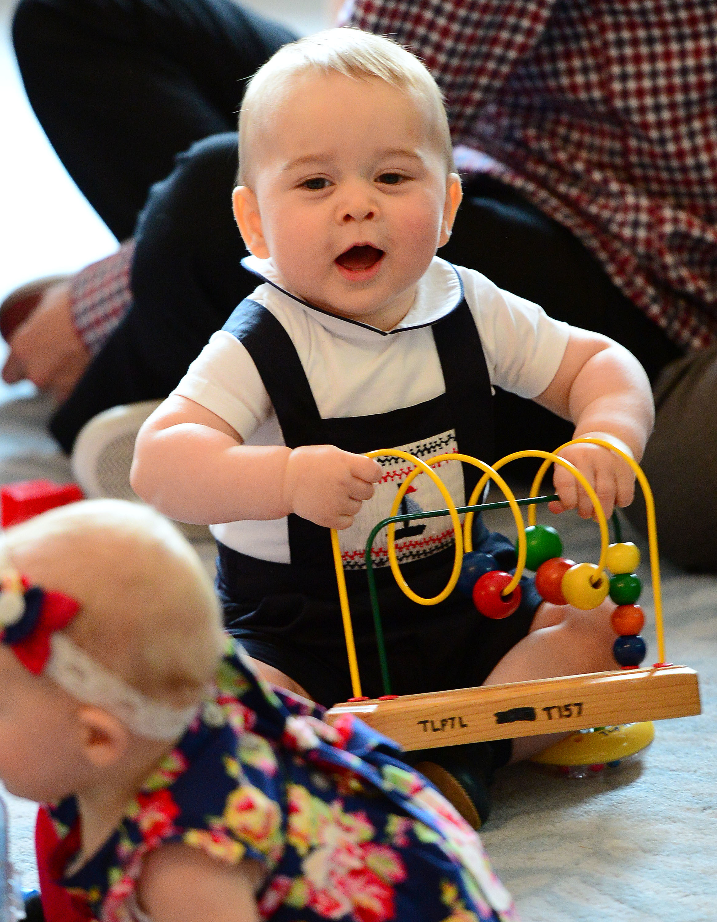 <p>Prince George of Cambridge played with a wooden bead maze at a Plunkett's Parent's Group playdate at Government House in Wellington, New Zealand, on April 9, 2014, during his parents' tour of the country.</p>