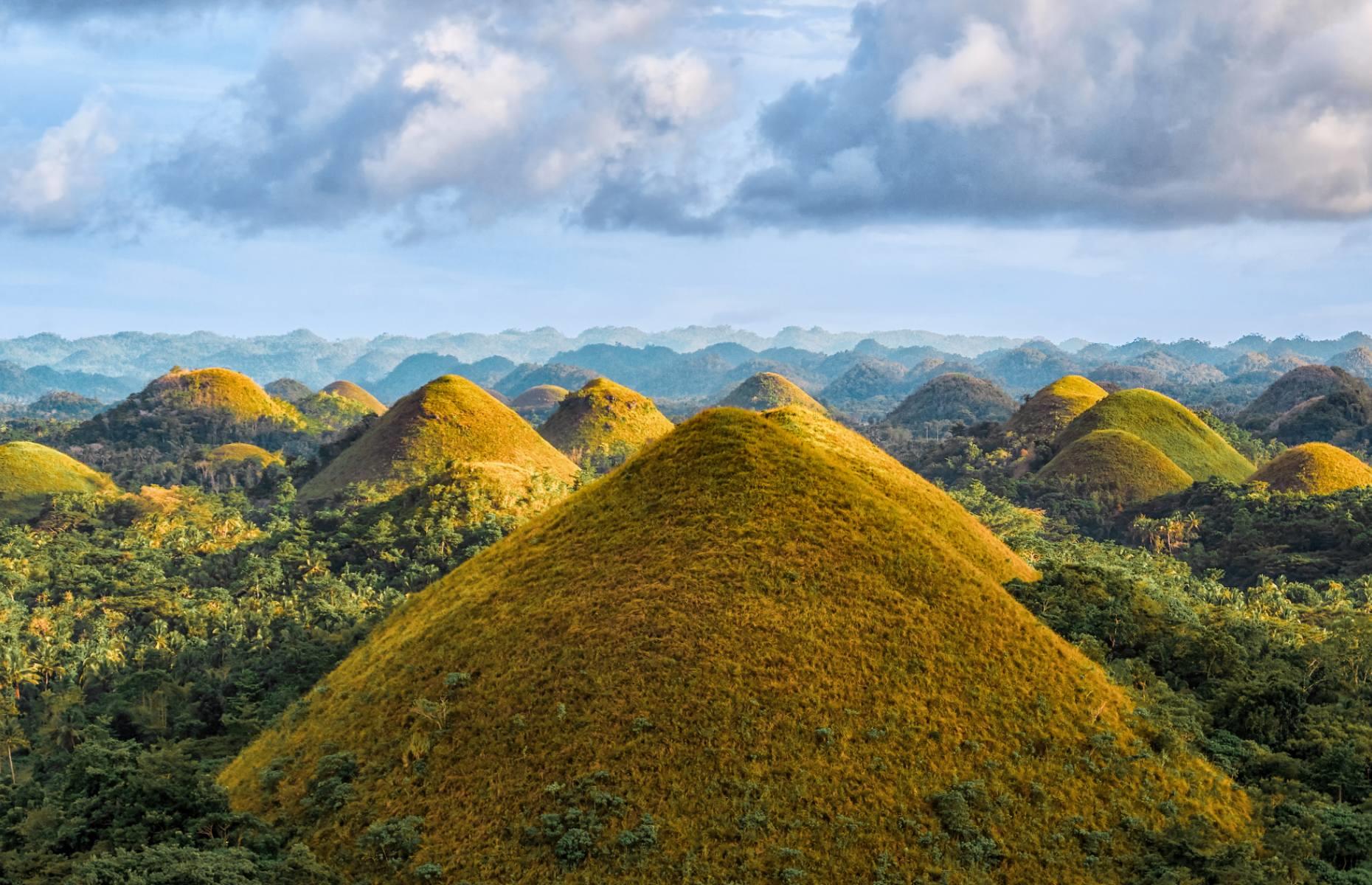 <p>So-named because they resemble little mounds of chocolate in the dry season – when their grassy coverings go from verdant green to brown – these otherworldly hills have puzzled scientists for decades. The peaks, which spread across 19 square miles (50sq km) on the island of Bohol in the Philippines, vary in size but have strikingly similar and symmetrical shapes as if created in molds.</p>