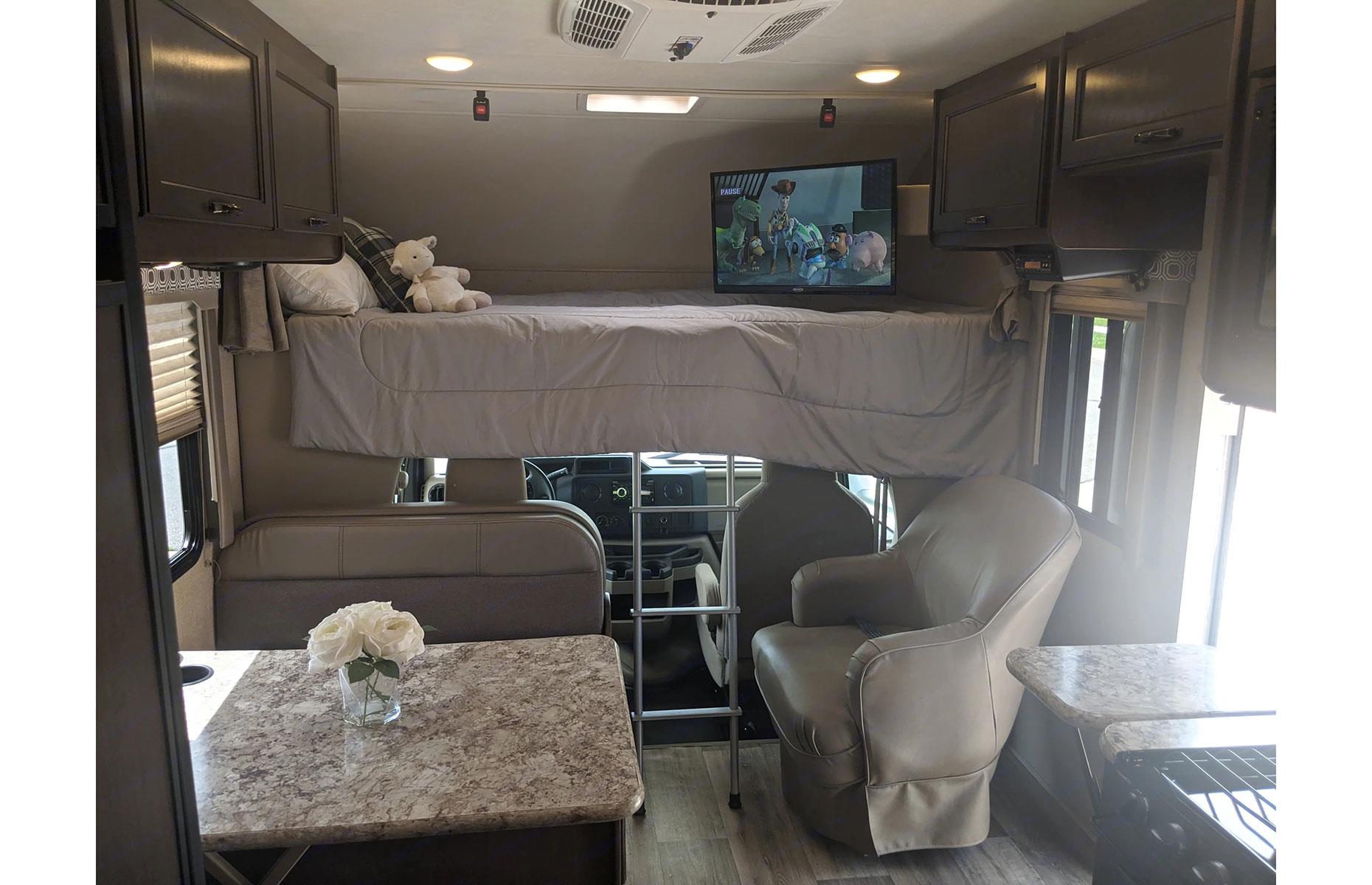 Two of the three beds can be found towards the front of the motorhome, including the sofa bed and dinette that double up as the living and dining areas. An over-cab bed sits above the driver’s seat (ideal for kids) with a flatscreen TV in the corner for easy access. Directly next to the kitchen is the double bed with a privacy curtain and next to that the bathroom with a toilet, sink and shower.