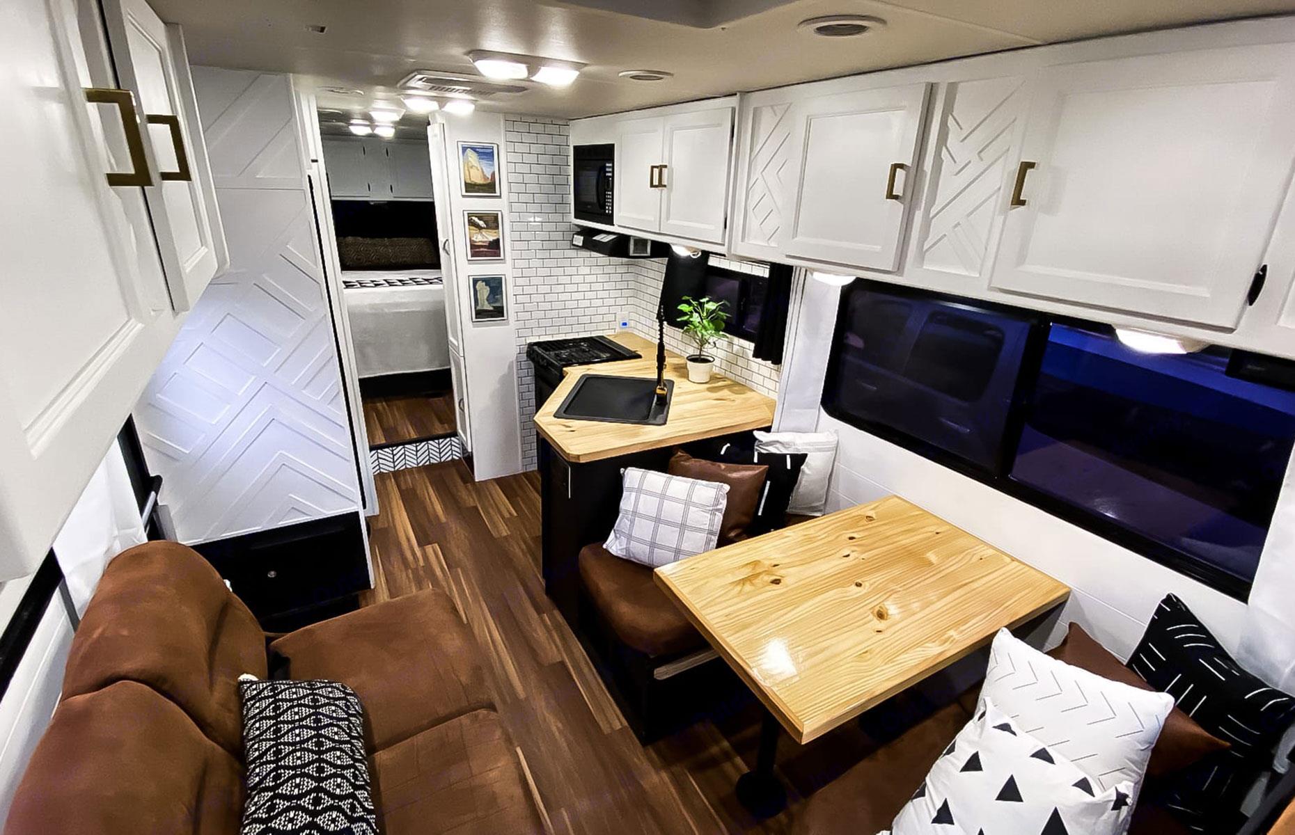 The RV’s sleek kitchen comes fully stocked with a microwave, stove, Keurig K-Cup coffee maker, cooking utensils, dishes, pots and pans and a drying rack. Opposite, the living area’s dinette and sofa both transform into two cozy beds. A cabin bed sits above the front seats and also includes a pull out 32” TV with an HDMI TV adapter for streaming from your mobile device, perfect for those longer drives.