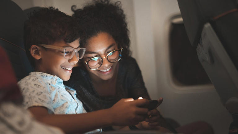 Children using smart phone during the flight