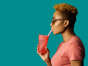 Profile portrait of a cool young  woman in pink holding a drinking cup and paper straw