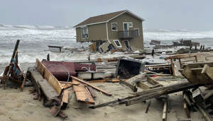 In this image provided by National Park Service, a beach house that collapsed along North Carolina's Outer Banks rest in the water on Tuesday, May 10, 2022, in Rodanthe, N.C. The home was located along Ocean Drive in the Outer Banks community of Rodanthe. The park service has closed off the area and warned that additional homes in the area may fall too.   (National Park Service via AP)