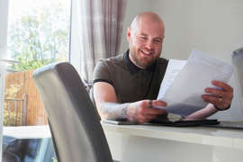 Man smiling reading a letter.