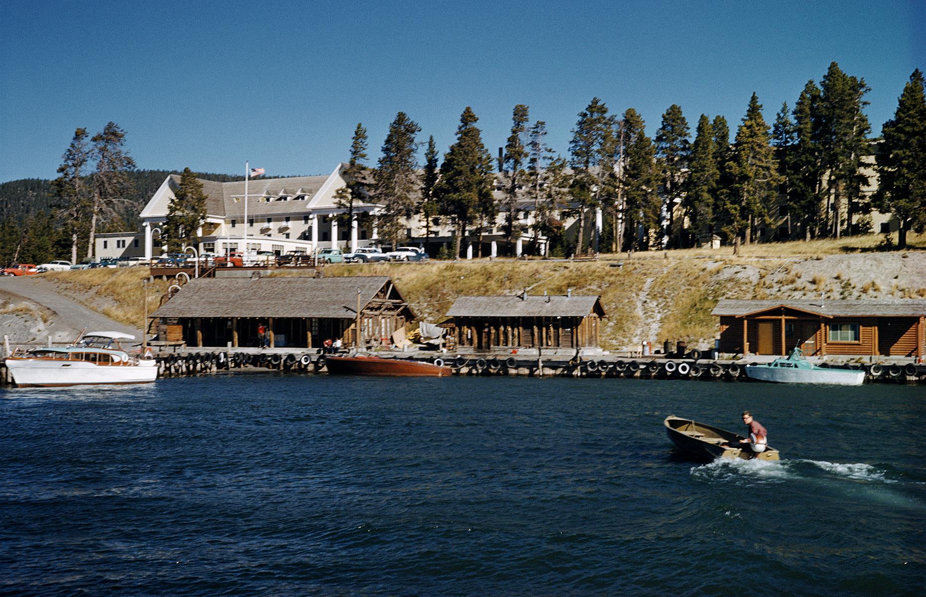 <p>By the 1960s, accommodation options in the park were varied, and a favored spot was <a href="https://www.yellowstonenationalparklodges.com/lodgings/cabin/lake-yellowstone-hotel-cabins/">Lake Yellowstone Hotel</a> (pictured). It's one of the oldest national park hotels in the USA, opened back in 1891, and predating the formation of the National Park Service itself. It's captured here in 1965, arranged along the edge of the water, which is busy with recreational boats. Today, it's a National Historic Landmark with a slew of deluxe lake-view rooms. </p>