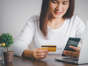 Woman shopping online with credit card shown on the back of the card and using smartphone for online shopping, Online payment concept.