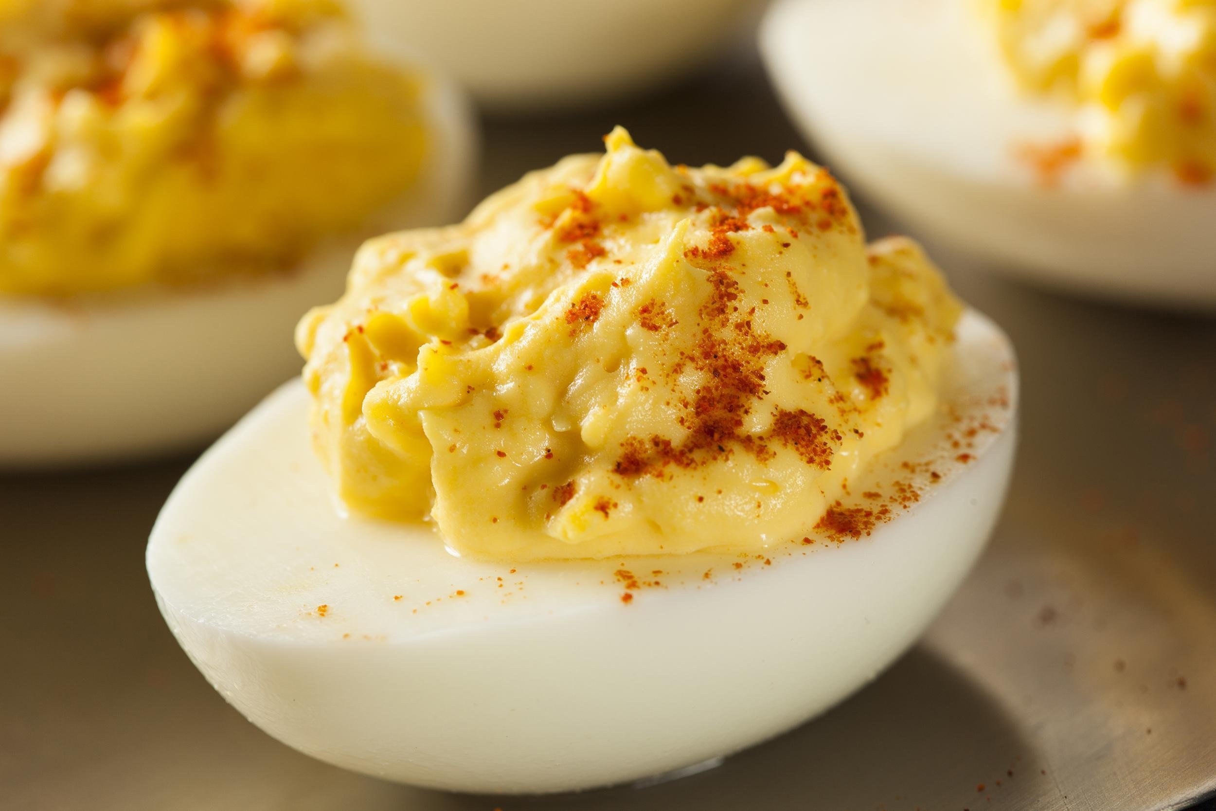 <p>"Deviled" eggs, sometimes called "stuffed" eggs, are simply hard-boiled eggs with the yolks removed, flavored, and returned to the white. Deviled eggs are a bite-sized, tasty <a href="https://blog.cheapism.com/favorite-retro-holiday-recipes/">party classic that never goes out of style</a>. They can also be perfect to enjoy with lunch or as an appetizer before dinner. When making deviled eggs, start by cutting hard-boiled eggs in half lengthwise and scooping out the yolks. In a bowl, combine the yolks and 2 tablespoons vegetable oil, 1 tablespoon lemon juice or vinegar, one-half teaspoon table salt, one-half teaspoon freshly ground pepper, and 1-and-a-half teaspoons yellow or spicy brown mustard. Mash together until smooth. Spoon the mixture back inside the yolk-less egg whites and <a href="https://blog.cheapism.com/leftover-recipes-3493/">sprinkle with paprika</a>. Serve immediately or store in the refrigerator for up to three days. These deviled eggs are delicious but can can be modified in an almost endless number of ways to cater to different tastes.</p>
