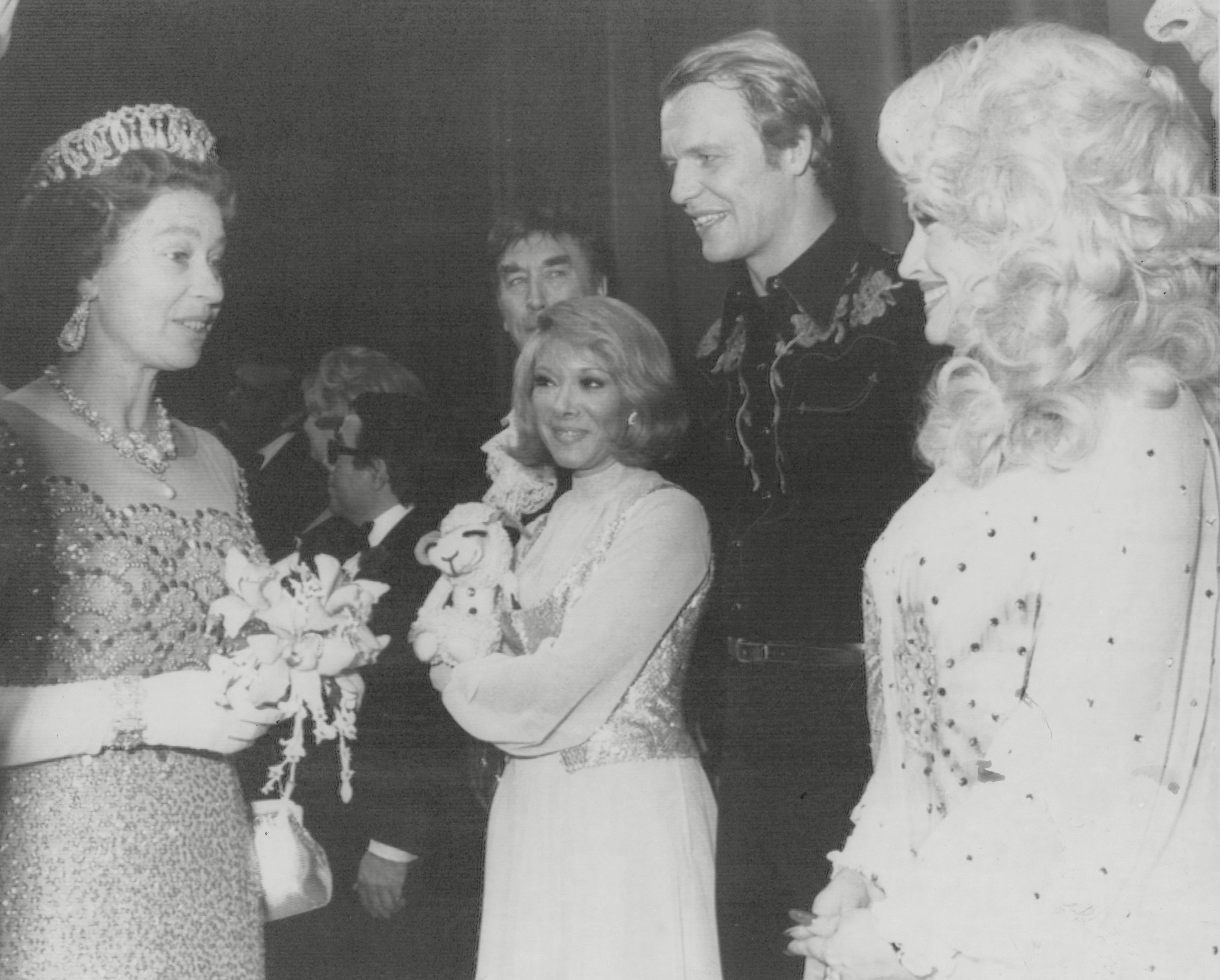 <p>Hollywood celebrities have made the cut in Scotland too: Queen Elizabeth II is seen here greeting "Lamb Chop's Play-Along" star Shari Lewis, "Starsky & Hutch" actor David Soul and country music legend Dolly Parton following a variety show in Glasgow during her Silver Jubilee tour of Scotland on May 17, 1977.</p>