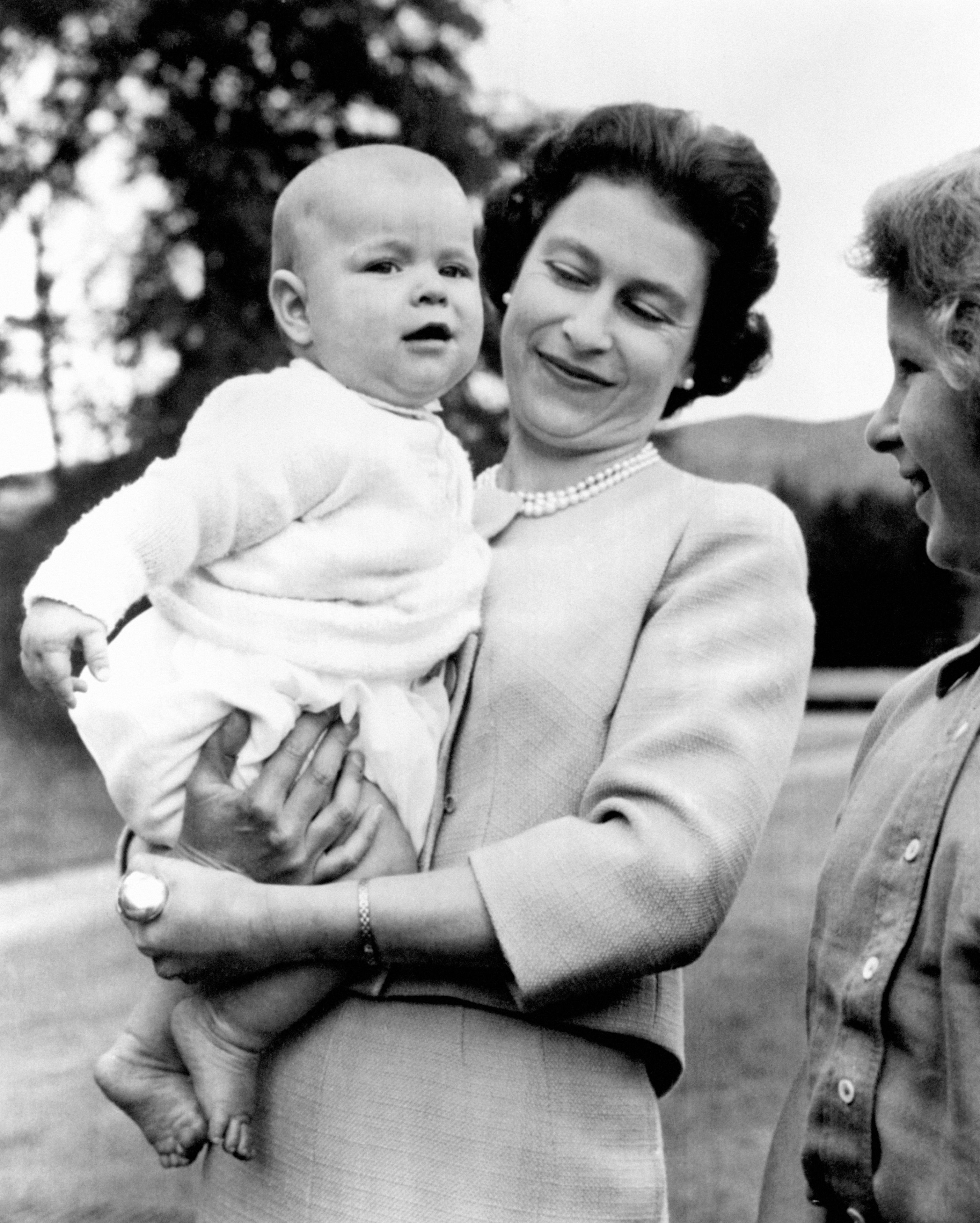 <p>Queen Elizabeth II carried a young Prince Andrew during an outing on the grounds of her home at Balmoral Castle in Scotland on Nov. 8, 1960.</p>