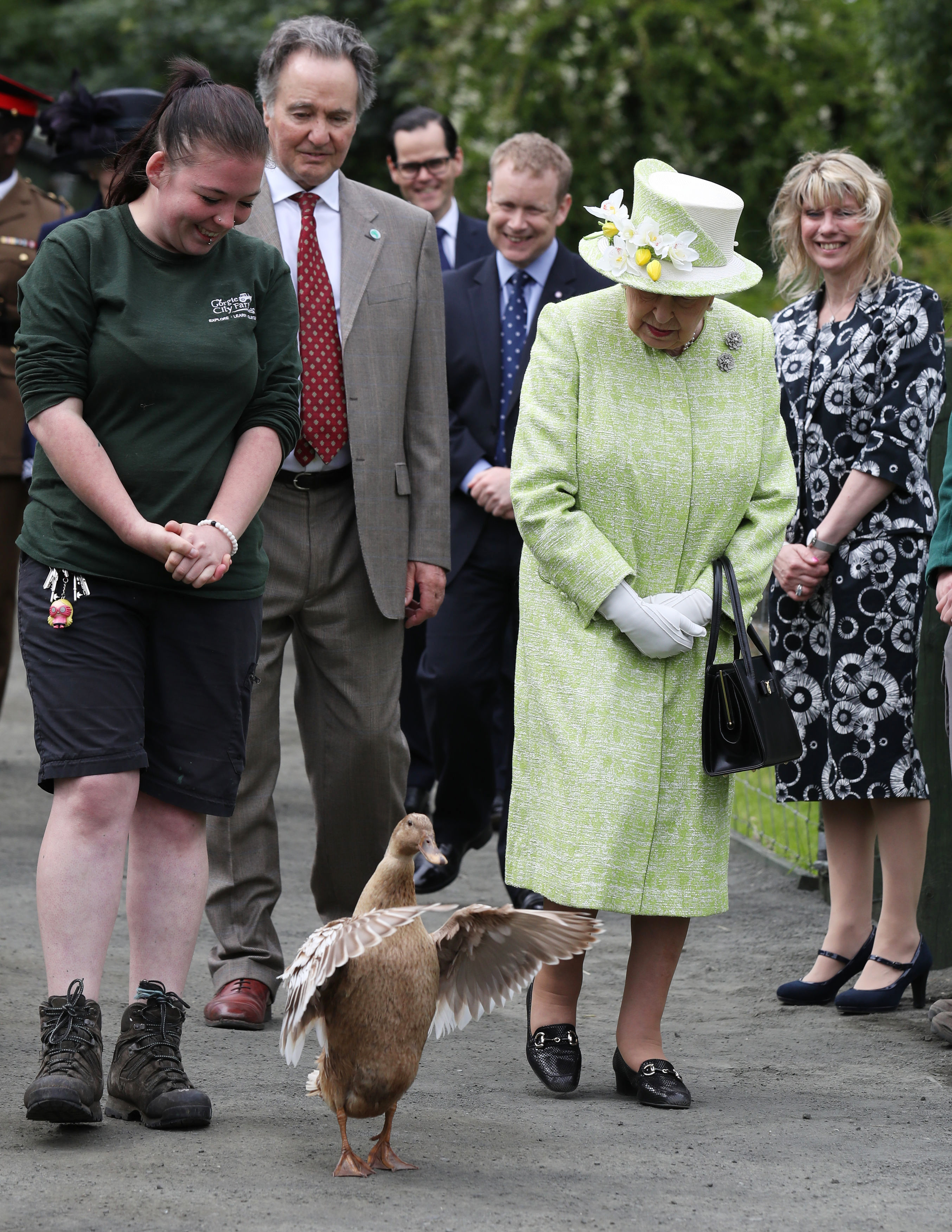 <p>Queen Elizabeth II chatted with keeper Maia Gordon as Olive the duck walked alongside them during a visit to Gorgie City Farm in Edinburgh, Scotland, on July 4, 2019.</p>
