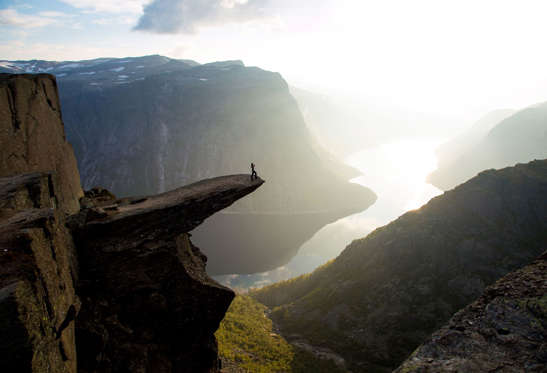 Trolltunga, Norway - Solent News/Rex Features Mandatory Credit: Photo by Solent News/REX Shutterstock (4217496e) A sightseer admires the view from the edge of Trolltunga People stand on the edge of a 700 metre-high cliff, Norway - Sep 2014 *Full story: http://www.rexfeatures.com/nanolink/pkfx A sightseer is seen doing yoga on the edge of a 700 metre-high cliff as she takes in the breathtaking views. Meanwhile, another group leap into the air while more careful visitors simply stand and admire the scenery. The photographs were taken by Christopher Baldry, 34, who was sitting on a rock nearby. The edge that his friends are standing on is a popular spot for photographers, called Trolltunga - which means 'Troll's Tongue.' Christopher took the shots whilst hiking on a cliff with friends in Norway, just a couple of hours away from his home. He said: "We got there at around 6.30pm and went straight out to get some shots before setting up camp. "There can be quite a lot of people up there, but by spending the night we were one group of people among maybe eight other groups. "It's about 700 metres above the lake below. The view is amazing".