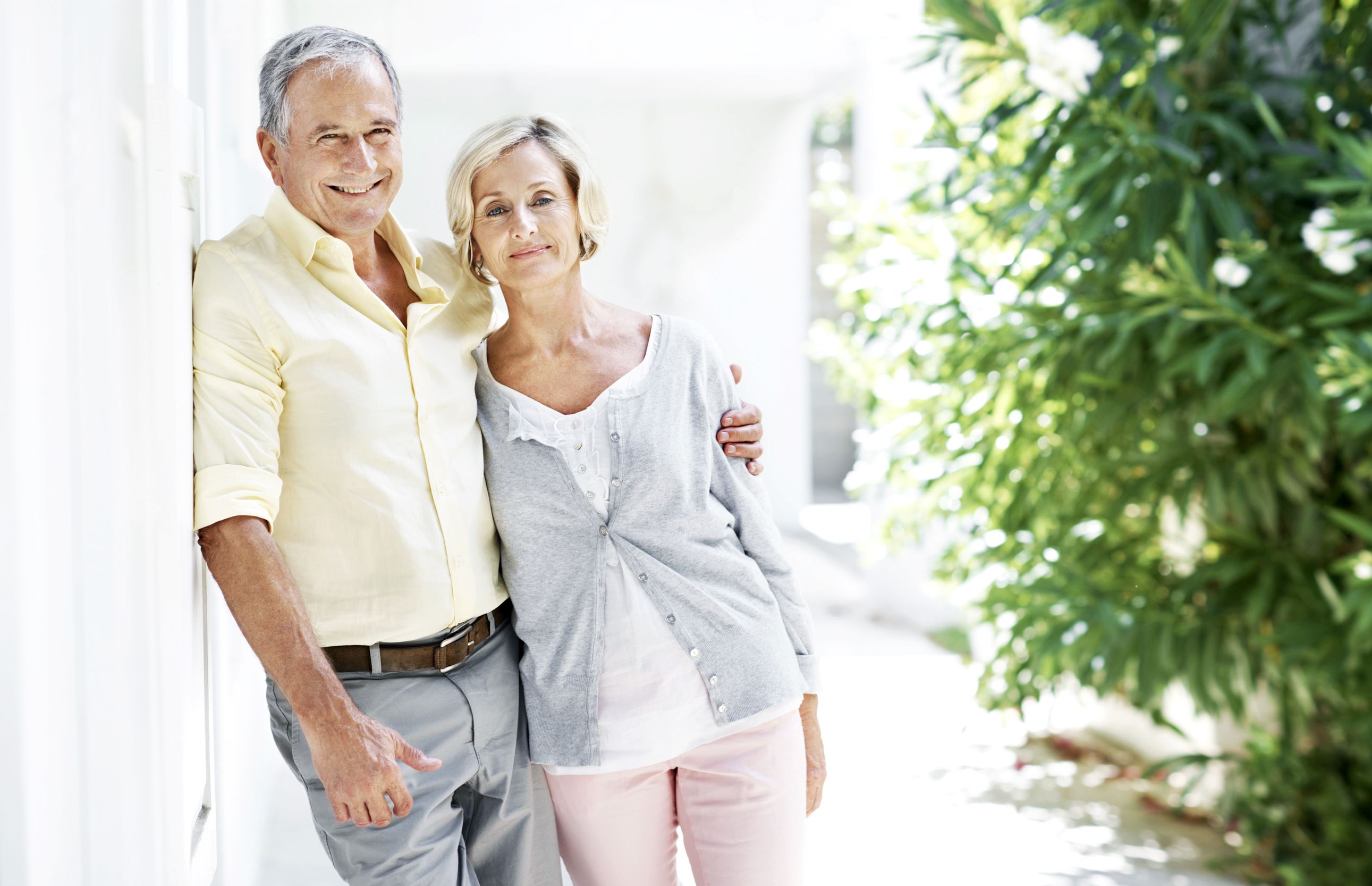 Older couple in front of their house.