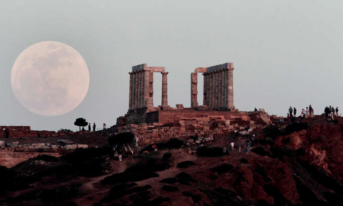 ÎÎ¹Î±ÏÎ¬Î½ÎµÎ¹Î± 3 Î±ÏÏ 42: The "supermoon" appears behind the Temple of Poseidon in Cape Sounion, south east of Athens, Greece, while tourists watch, on Saturday, May 5, 2012. The moon was the closest it will get to the Earth this year _ and appeared 14 percent larger because of that. At its peak it was about 221,802 miles from Earth.