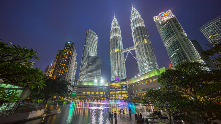 ÎÎ¹Î±ÏÎ¬Î½ÎµÎ¹Î± 32 Î±ÏÏ 41: Kuala Lumpur, Malaysia - August 1, 2015: Water Fountain at Suria Klcc with Petronas Towers and Office Buildings at Blue Hour sunset at Night. It's a popular shopping attraction to locals and tourists.