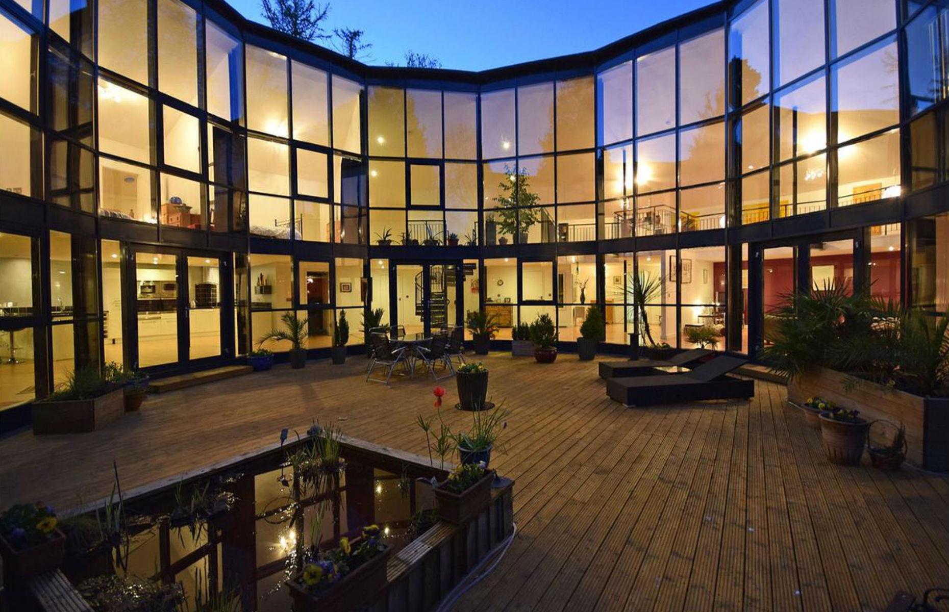 Slide 24 of 54: The home literally towers above you from the central courtyard and the wooded grounds extend to about an acre.