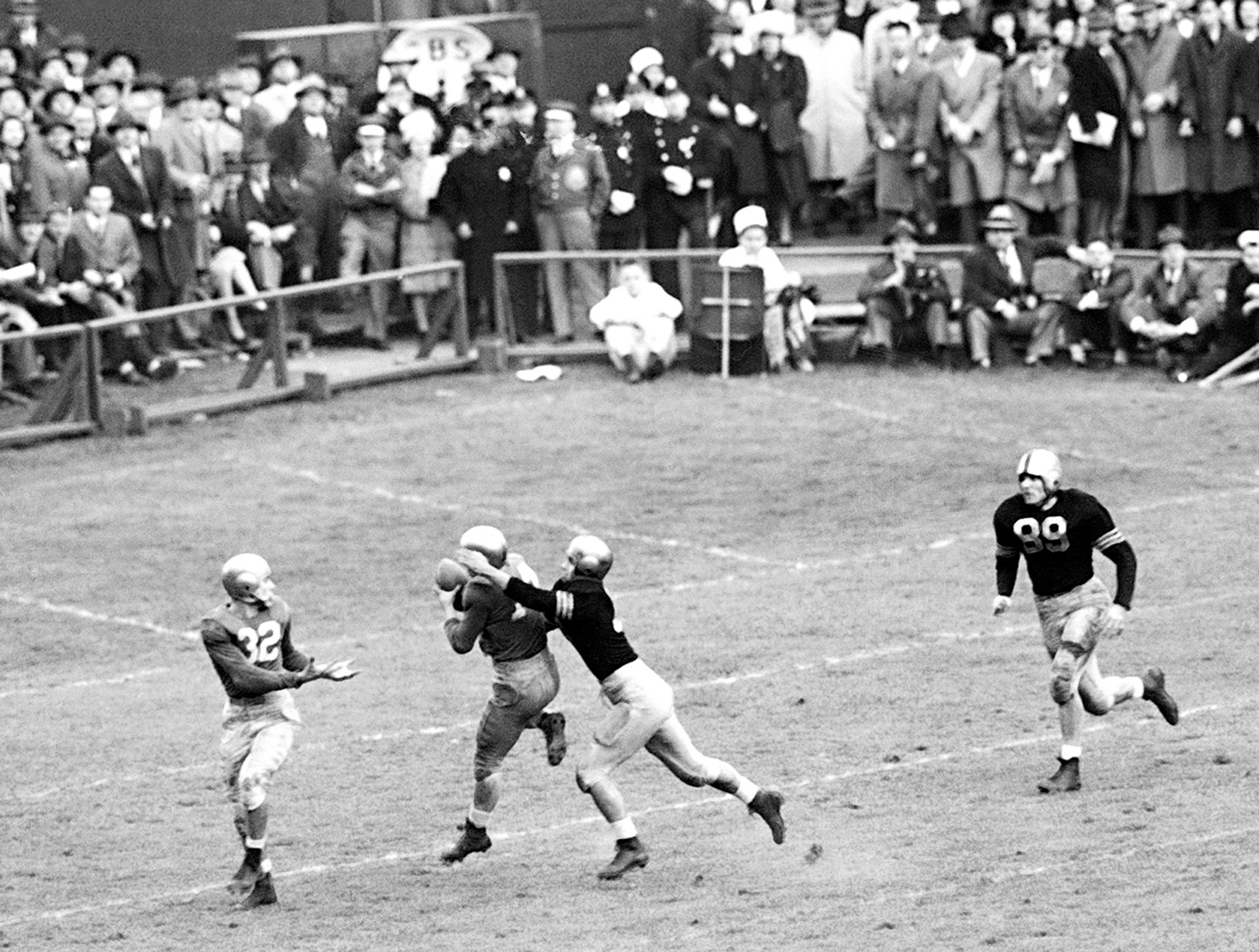 Slide 5 of 10: Notre Dame Back Emil Sitko (14) grabs a pass intended for Army Back Bill West (36) (right) during the fourth quarter of the Notre Dame-Army at Yankee Stadium, Nov. 9, 1946, New York. Notre Dame Quarterback John Lujack (32) holds out hands for possible lateral. Game ended in a scoreless tie.