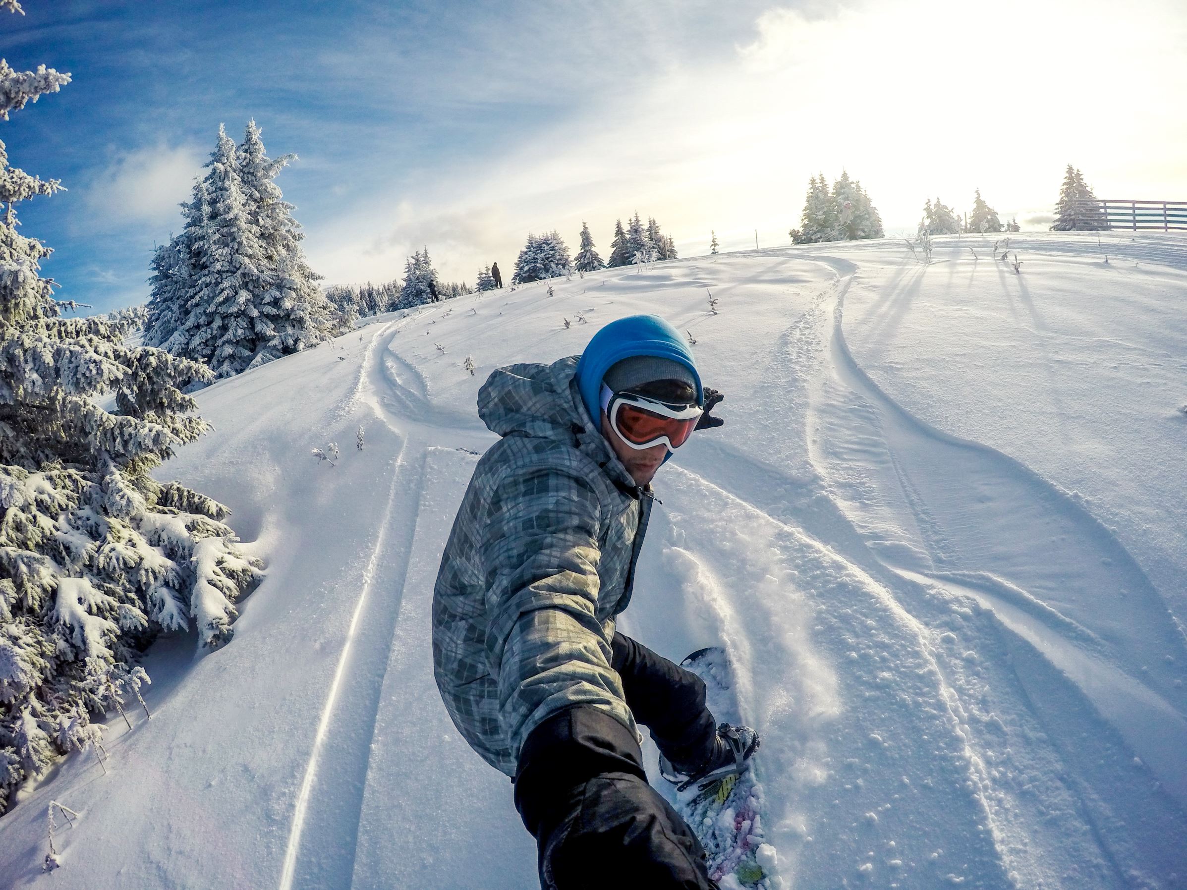 Snowboarder takes a selfie on the top of mountain peak.