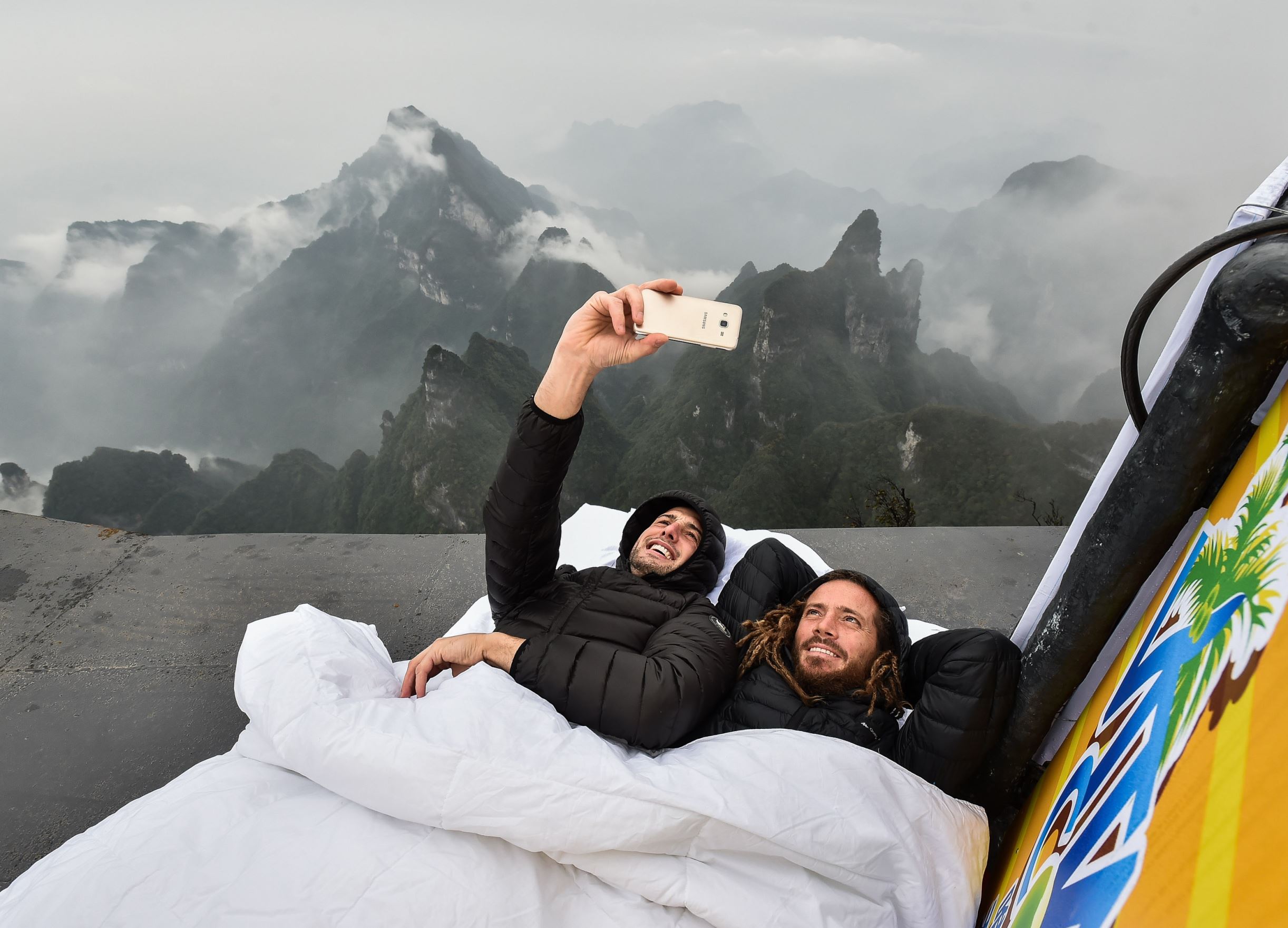 Graham Dickinson and Rob Heron of Canada pose for a selfie while lying on the jumping platform before the qualification of World Wingsuit League (WWL) China Grand Prix 2016 in Zhangjiajie, central China's Hunan Province, Oct. 13, 2016.
