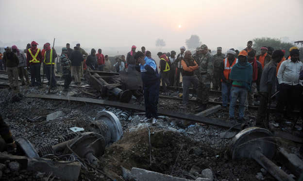 Slide 2 of 15: Rescue worker and onlookers stand near the wreckage of the train on the damaged tracks where a train derailed near Pukhrayan in Kanpur district on November 21, 2016.
Emergency workers raced to find any more survivors in the mangled wreckage of an Indian 