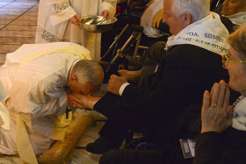 Diapositiva 4 de 23: Pope Francis (L) kisses the foot of a man as he performs the traditional Washing of the feet during a visit at a center for disabled people as part of  Holy Thursday (Maundy Thursday) as part of the Holy Week on April 17, 2014 in Rome.  AFP PHOTO / ALBER