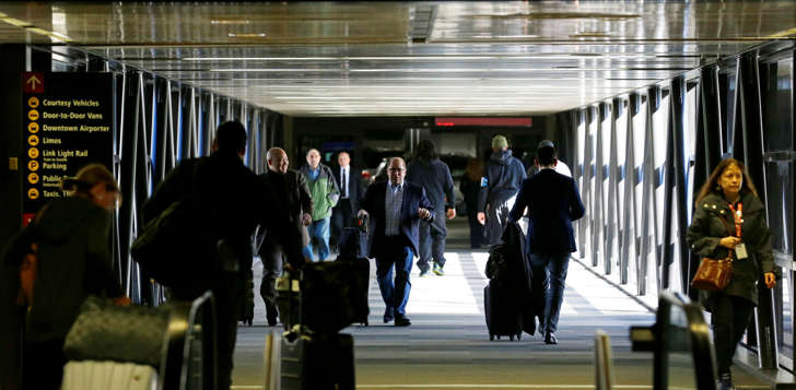 Pedestrians walk through a skybridge at Seattle-Tacoma International Airport near the international arrivals area, Tuesday, Feb. 28, 2017, in Seattle. Airport officials and civil rights lawyers around the country are getting ready for President Donald Trump's new travel ban, which is expected to be released as soon as Wednesday.