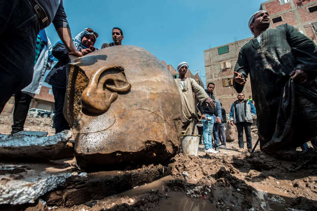 Slide 1 of 14: Egyptian workers look at the site of a new discovery by a team of German-Egyptian archeologists in Cairo's Mattarya district on March 9, 2017. Statues of the kings and queens of the nineteenth dynasty (1295 - 1185 BC) were unearthed in the vicinity of th