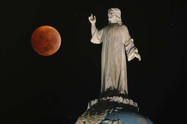 Slide 4 of 53: A double expousure picture shows the moon and the monument of The Savior of The World during a total lunar eclipse as seen from San Salvador, El Salvador on December 21, 2010. This eclipse takes place just hours before the December solstice, which marks the beginning of northern winter and southern summer. AFP PHOTO/ Jose CABEZAS (Photo credit should read Jose CABEZAS/AFP/Getty Images)