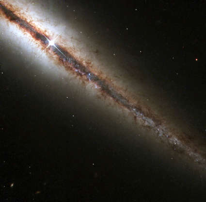 Slide 50 of 86: 386160 01: An image produced by the Hubble telescope of the perfectly 'edge-on' galaxy, or NGC 4013 , March 1, 2001. This new Hubble picture reveals, with great detail, huge clouds of dust and gas extending along, as well as far above, the galaxy's main disk. NGC 4013 is a spiral galaxy, similar to the Milky Way, lying some 55 million light-years from Earth in the direction of the constellation Ursa Major. Viewed face-on, it would look like a nearly circular pinwheel, but NGC 4013 happens to be seen edge-on from our vantage point. Even at 55 million light-years, the galaxy is larger than Hubble's field of view, and the image shows only a little more than half of the object, albeit with unprecedented detail. (Photo Courtesy of NASA/Newsmakers)
