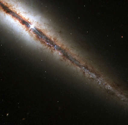 NGC 4013 - Newsmakers/NASA Slide 50 of 86: 386160 01: An image produced by the Hubble telescope of the perfectly 'edge-on' galaxy, or NGC 4013 , March 1, 2001. This new Hubble picture reveals, with great detail, huge clouds of dust and gas extending along, as well as far above, the galaxy's main disk. NGC 4013 is a spiral galaxy, similar to the Milky Way, lying some 55 million light-years from Earth in the direction of the constellation Ursa Major. Viewed face-on, it would look like a nearly circular pinwheel, but NGC 4013 happens to be seen edge-on from our vantage point. Even at 55 million light-years, the galaxy is larger than Hubble's field of view, and the image shows only a little more than half of the object, albeit with unprecedented detail. (Photo Courtesy of NASA/Newsmakers)