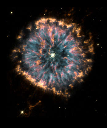 Slide 55 of 86: UNITED STATES - OCTOBER 29: Glowing in the constellation Aquila like a giant eye, the nebula NGC 6751, is a cloud of gas ejected several thousand years ago from the hot star visible in its centre. The hubble observations were obtained in 1998 with the Wide Field Planetary Camera 2 (WFPC2) by a team of astronomers led by Arsen Hajian of the US Naval Observatory in Washington DC. The nebula shows several remarkable and poorly understood features. Blue regions mark the hottest glowing gas, which forms a roughly circular ring around the central stellar remnant. Orange and red show the locations of cooler gas. (Photo by SSPL/Getty Images)