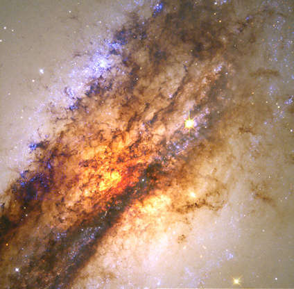 Centaurus A - ESA/STScI/NASA Slide 83 of 86: The image above only begins to describe Hubble's ability to amaze with both beauty and science. A massive black hole hidden at the center of nearby galaxy, Centaurus A, feeds on a smaller galaxy in a spectacular collision.