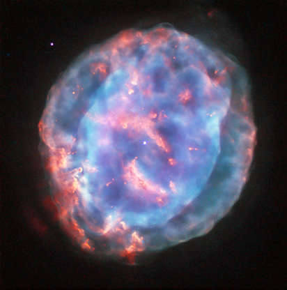 Little Gem Nebula - J. Schmidt/ESA/Hubble & NASA Slide 72 of 86: The NASA/ESA Hubble Space Telescope had imaged NGC 6818 before, but it took another look at this planetary nebula, with a new mix of colour filters, to display it in all its beauty. By showing off its stunning turquoise and rose quartz tones in this image, NGC 6818 lives up to its popular name: Little Gem Nebula. This cloud of gas formed some 3500 years ago when a star like the Sun reached the end of its life and ejected its outer layers into space. As the layers of stellar material spread out from the nucleus – the white stellar remnant at the centre of the image – they ended up acquiring unusual shapes. NGC 6818 features pinkish knotty filaments and two distinct turquoise layers: a bright, oval inner region and, draped over it like sheer fabric, a spherical outer region. The central star has a faint stellar companion 150 astronomical units away, or five times the distance between the Sun and Neptune. You can just about make this out: if you zoom in to the centre, you’ll notice the white dot in the middle is not perfectly round, but rather two dots very close together. With a diameter of just over half a light-year, the planetary nebula itself is about 250 times larger than the binary system. But the nebula material is still close enough to its parent star for the ultraviolet radiation the star releases to ionise the dusty gas and make it glow. Scientists believe the star also releases a high-speed flow of particles – a stellar wind – that is responsible for the oval shape of the inner region of the nebula. The fast wind sweeps away the slowly moving dusty gas, piercing its inner bubble at the oval ends, seen at the lower left and top right corners of the image. NGC 6818 is located in the constellation of Sagittarius and is about 6000 light-years from Earth. It was first imaged by the Hubble Space Telescope’s Wide Field Planetary Camera 2 in 1997, and again in 1998 and 2000 using different colour filters to highlight different gases in the nebula.