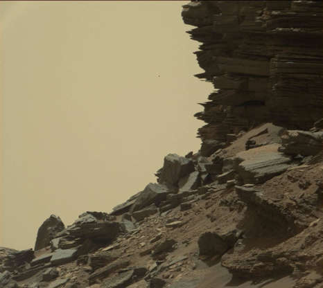 Slide 27 of 86: This view from the Mast Camera (Mastcam) in NASA's Curiosity Mars rover shows a hillside outcrop with layered rocks within the "Murray Buttes" region on lower Mount Sharp. The buttes and mesas rising above the surface in this area are eroded remnants of ancient sandstone that originated when winds deposited sand after lower Mount Sharp had formed. Curiosity closely examined that layer -- called the "Stimson formation" -- during the first half of 2016, while crossing a feature called "Naukluft Plateau" between two exposures of the Murray formation. The layering within the sandstone is called "cross-bedding" and indicates that the sandstone was deposited by wind as migrating sand dunes. The image was taken on Sept. 8, 2016, during the 1454th Martian day, or sol, of Curiosity's work on Mars.