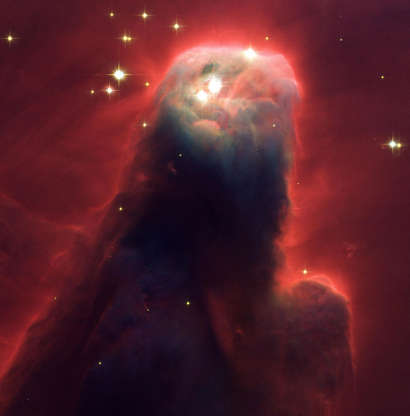 Slide 49 of 86: Resembling a nightmarish beast rearing its head from a crimson sea, this monstrous object is actually an innocuous pillar of gas and dust. Called the Cone Nebula (NGC 2264) ? so named because, in ground-based images, it has a conical shape ? this giant pillar resides in a turbulent star-forming region. This picture, taken by the newly installed Advanced Camera for Surveys (ACS) aboard NASA's Hubble Space Telescope, shows the upper 2.5 light-years of the nebula, a height that equals 23 million roundtrips to the Moon. The entire nebula is 7 light-years long. The Cone Nebula resides 2,500 light-years away in the constellation Monoceros (Photo by NASA/WireImage) *** Local Caption ***