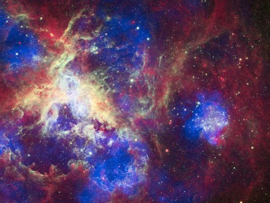 Slide 39 of 86: UNSPECIFIED, APRIL 23: A new view of the Tarantula Nebula on April 23, 2012. To celebrate its 22nd anniversary in orbit, the Hubble Space Telescope released a dramatic new image of the star-forming region 30 Doradus, also known as the Tarantula Nebula because its glowing filaments resemble spider legs. A new image from all three of NASA's Great Observatories--Chandra, Hubble, and Spitzer--has also been created to mark the event. The nebula is located in the neighboring galaxy called the Large Magellanic Cloud, and is one of the largest star-forming regions located close to the Milky Way. At the center of 30 Doradus, thousands of massive stars are blowing off material and producing intense radiation along with powerful winds. The Chandra X-ray Observatory detects gas that has been heated to millions of degrees by these stellar winds and also by supernova explosions. These X-rays, colored blue in this composite image, come from shock fronts--similar to sonic booms--formed by this high-energy stellar activity. The Hubble data in the composite image, colored green, reveals the light from these massive stars along with different stages of star birth, including embryonic stars a few thousand years old still wrapped in cocoons of dark gas. Infrared emission data from Spitzer, seen in red, shows cooler gas and dust that have giant bubbles carved into them. These bubbles are sculpted by the same searing radiation and strong winds that comes from the massive stars at the center of 30 Doradus. PHOTOGRAPH BY Barcroft Media /Barcoft Media via Getty Images