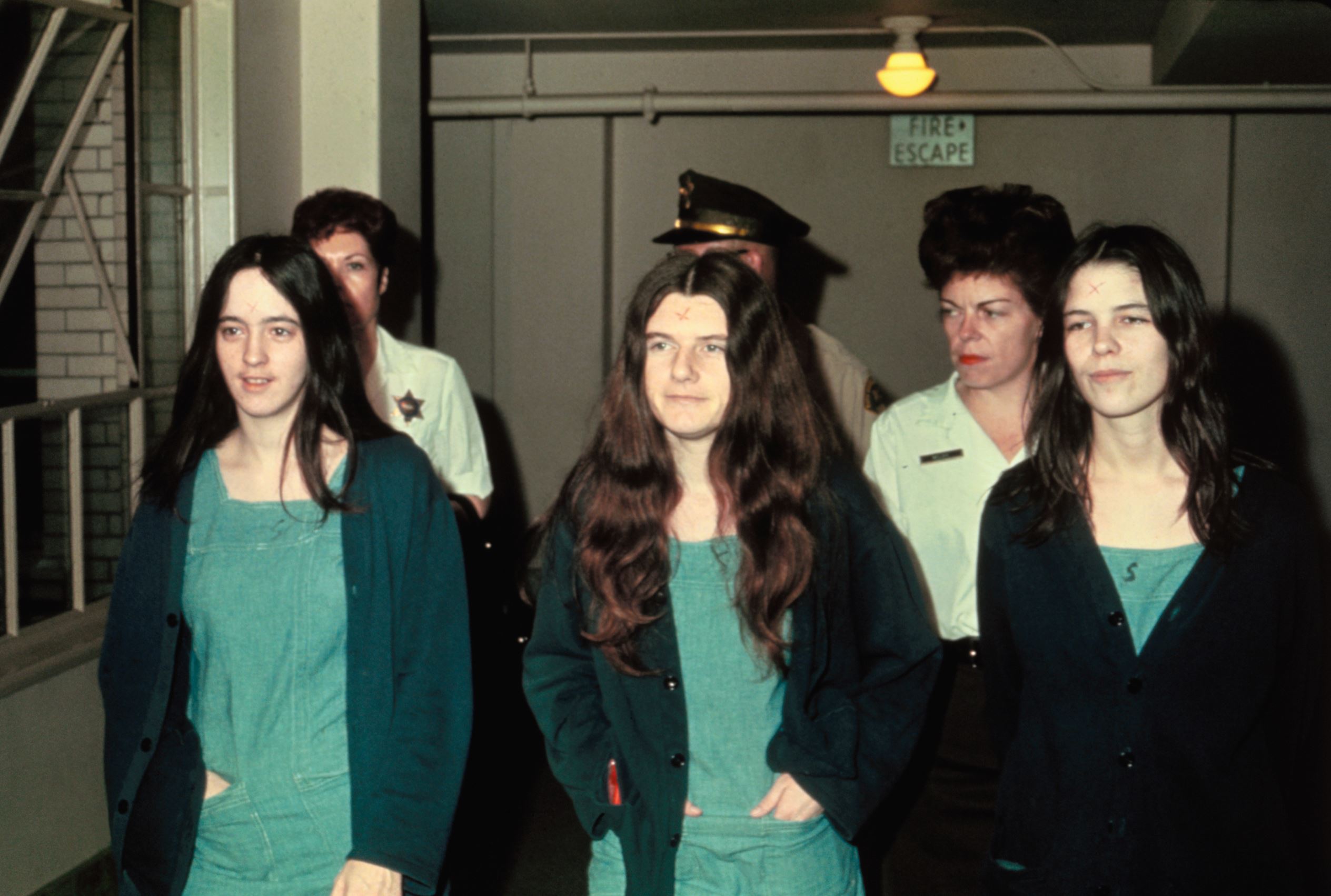 Slide 7 of 9: Image Caption: Manson family members and murder suspects Susan Atkins, Patricia Krenwinkle, and Leslie van Houton.