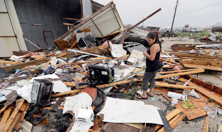 Jennifer Bryant looks over the debris from her family business destroyed by Hurricane Harvey Saturday, Aug. 26, 2017, in Katy, Texas. Harvey rolled over the Texas Gulf Coast on Saturday, smashing homes and businesses and lashing the shore with wind and rain so intense that drivers were forced off the road because they could not see in front of them.