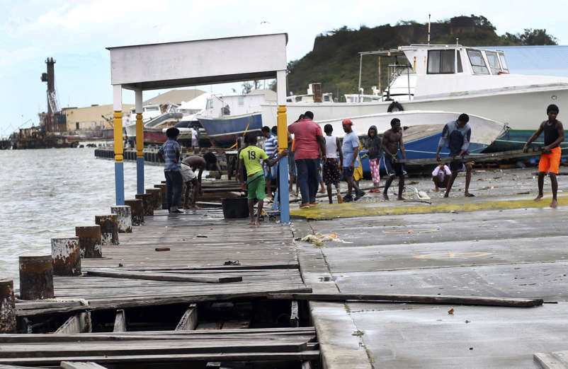 Slide 25 of 31: People recover broken parts of the dock after the passing of Hurricane Irma, in St. John's, Antigua and Barbuda, Wednesday, Sept. 6, 2017. Heavy rain and 185-mph winds lashed the Virgin Islands and Puerto Rico's northeast coast as Irma, the strongest Atlantic Ocean hurricane ever measured, roared through Caribbean islands on its way to a possible hit on South Florida. (AP Photo/Johnny Jno-Baptiste)