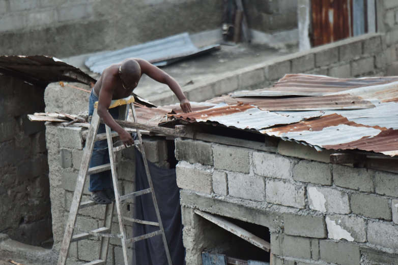 Slide 4 of 46: A man repairs a part of his roof in preparation for the arrival of Hurricane Irma in Lauriers neighborhood of Cap-Haitien, on September 6, 2017, 240 km from Port-au-Prince. / AFP PHOTO / HECTOR RETAMAL        (Photo credit should read HECTOR RETAMAL/AFP/Getty Images)