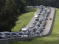 A car rides in the shoulder to pass other cars in evacuation traffic on I-75 N, near Brooksville, Fla., in advance of Hurricane Irma, Saturday, Sept, 9, 2017.