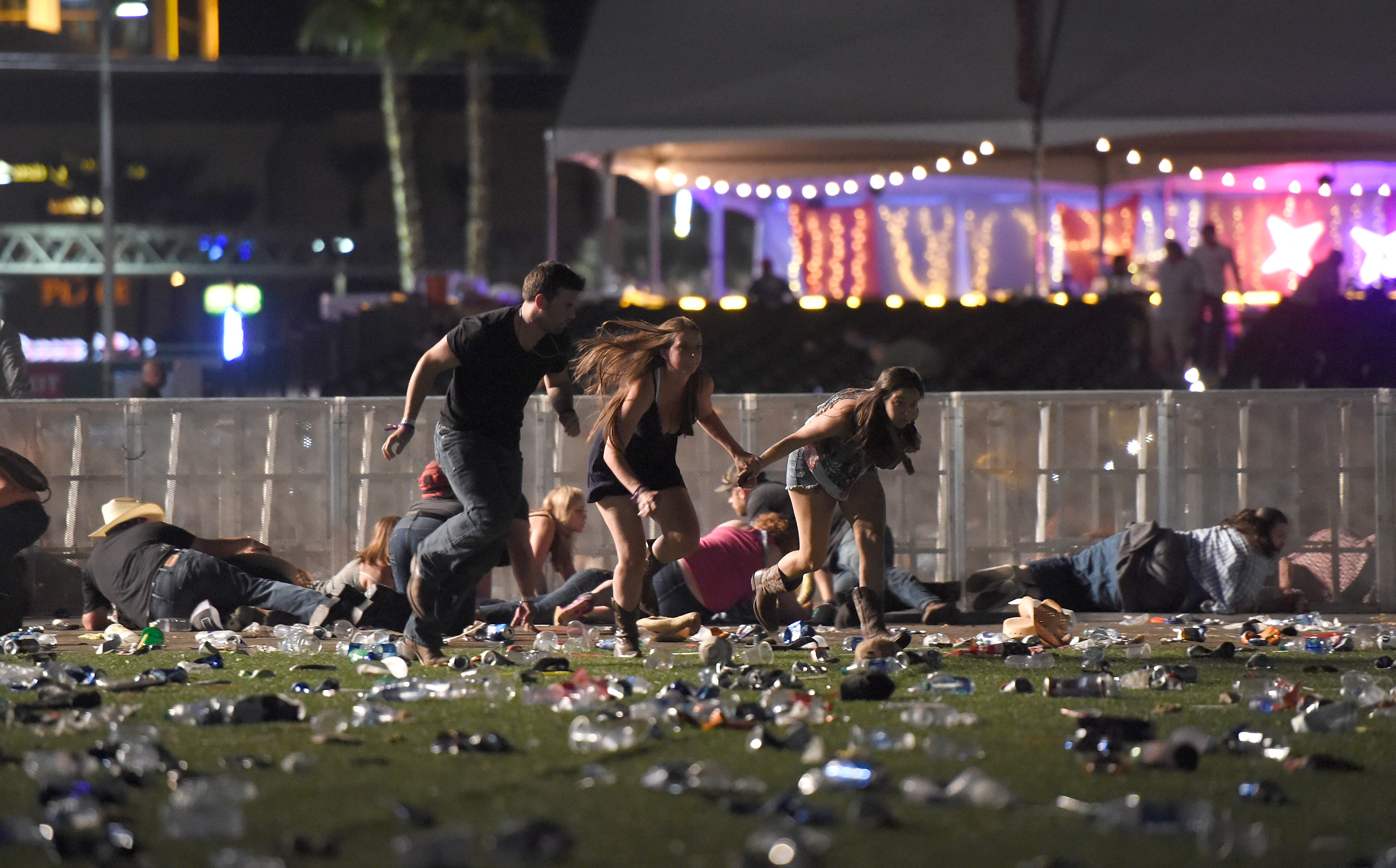 Diapositiva 48 de 57: People run from the Route 91 Harvest country music festival after apparent gun fire was heard on October 1, 2017 in Las Vegas, Nevada. There are reports of an active shooter around the Mandalay Bay Resort and Casino.